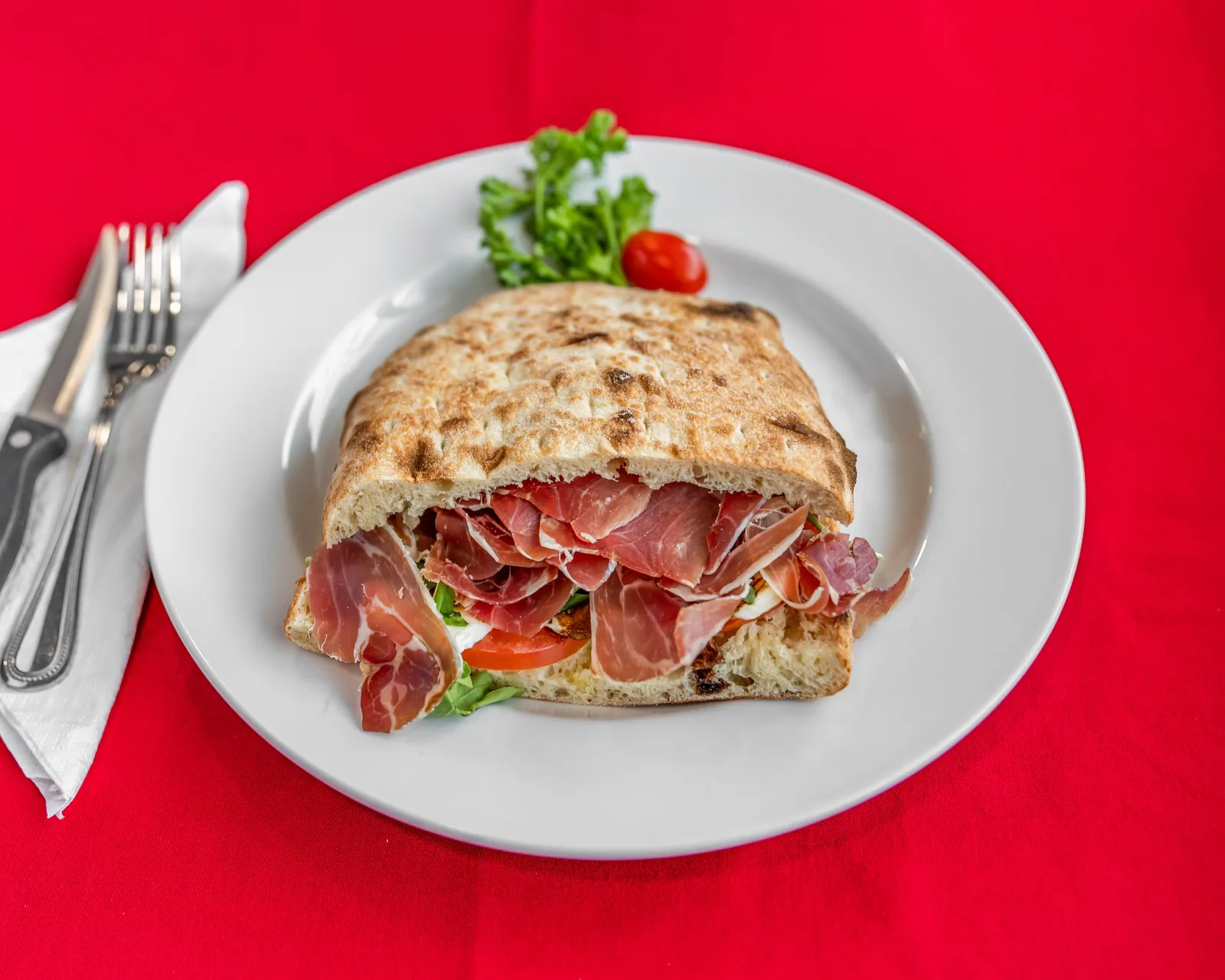 Prosciutto panini with tomato, bocconcini, balsamic drizzle, and arugula